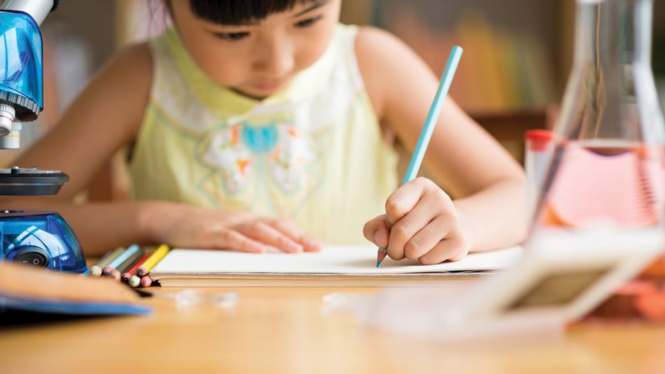 Girl at her desk writing paper