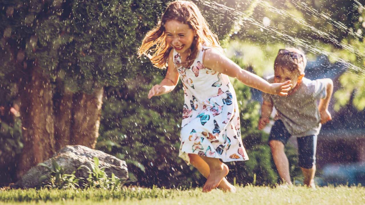 kids running in sprinkler