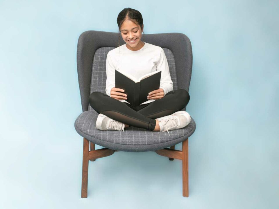 Girl reading a book in chair