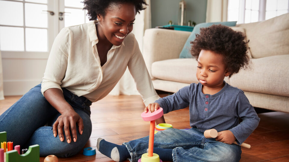 mom playing with her kid, teaching him to match shapes to correct colors